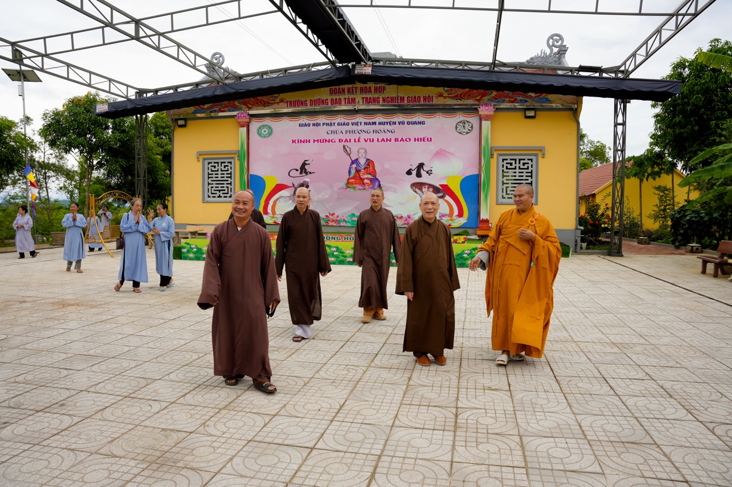 A group of men in robes walking in a courtyard Description automatically generated