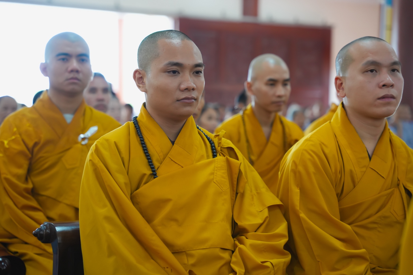 A group of men in yellow robes Description automatically generated