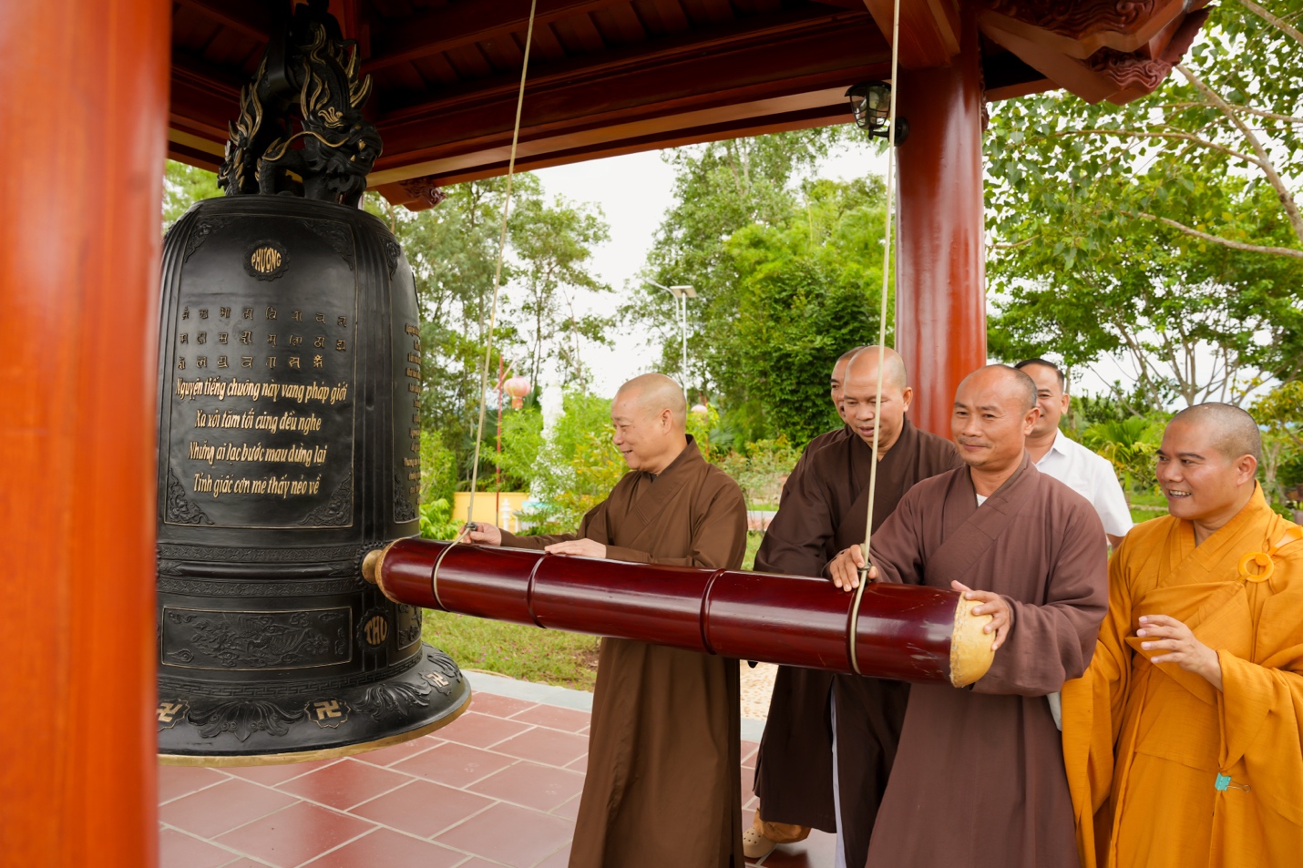 A group of men standing around a large bell Description automatically generated