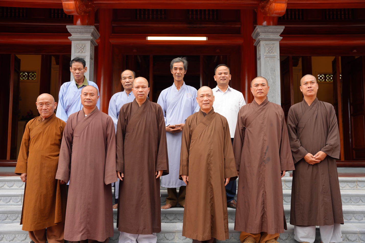 A group of men standing in front of a building Description automatically generated