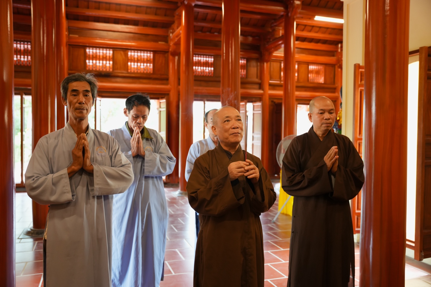 A group of people praying in a room Description automatically generated