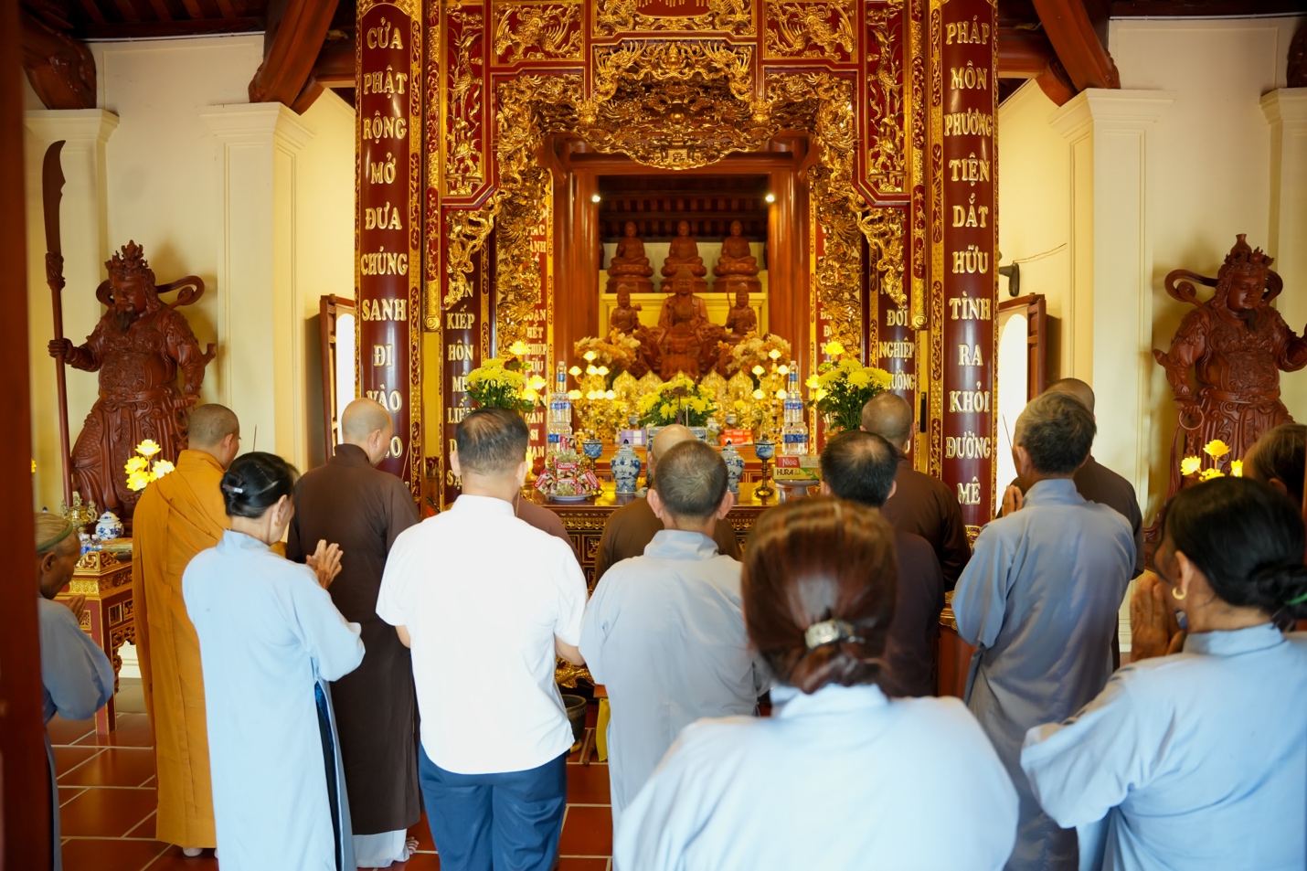 A group of people praying in a temple Description automatically generated