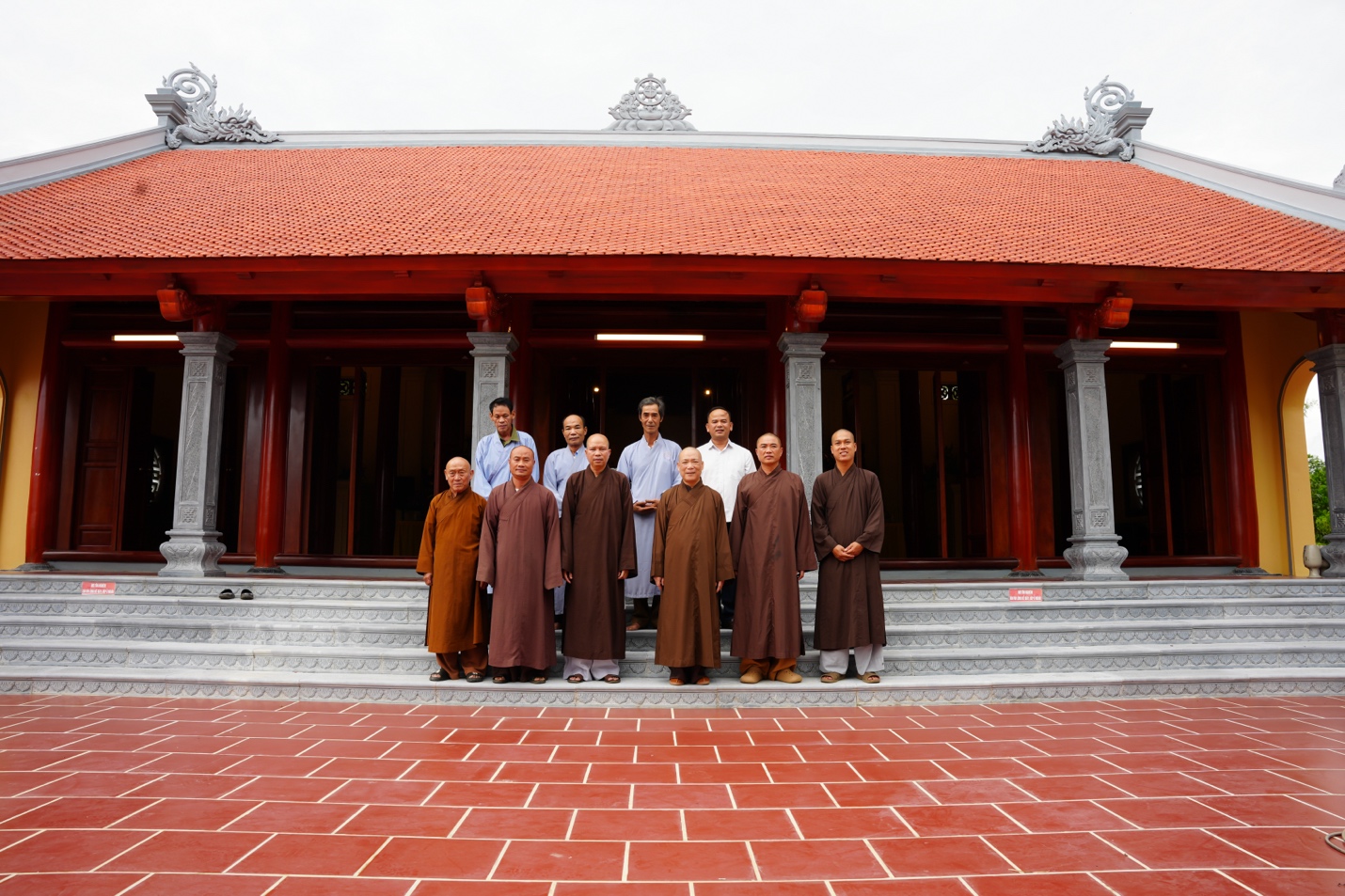 A group of people standing in front of a building Description automatically generated