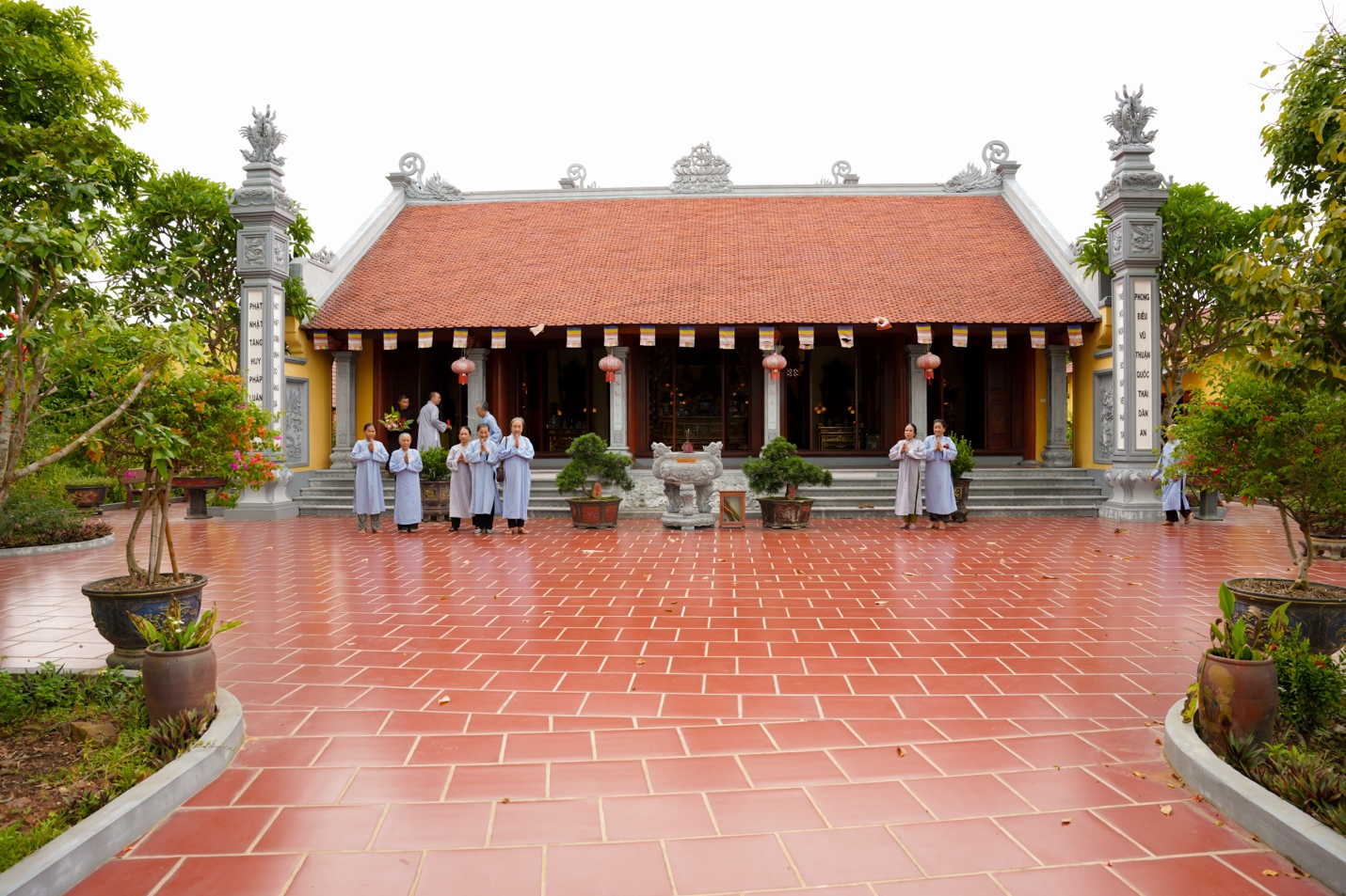 A group of people standing in front of a building Description automatically generated