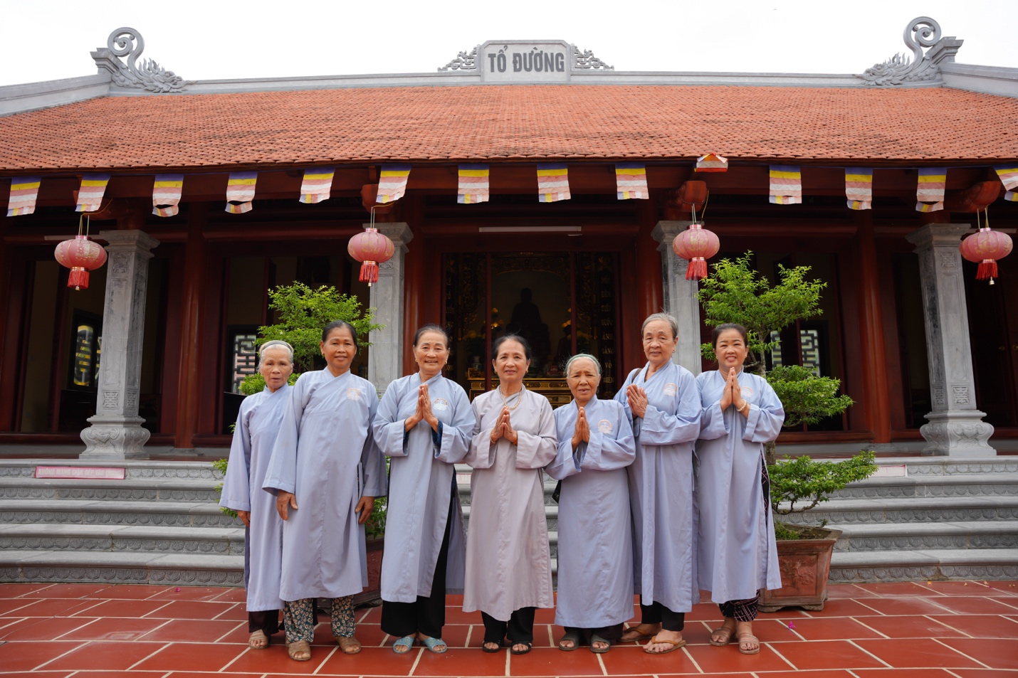 A group of women in robes standing in front of a building Description automatically generated