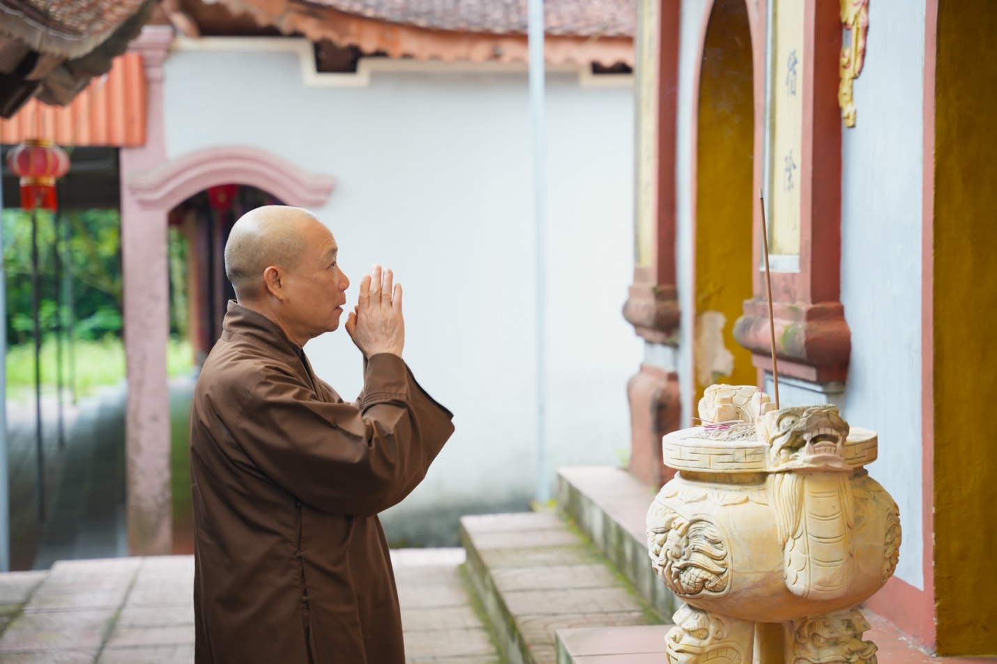 A person praying outside a building Description automatically generated