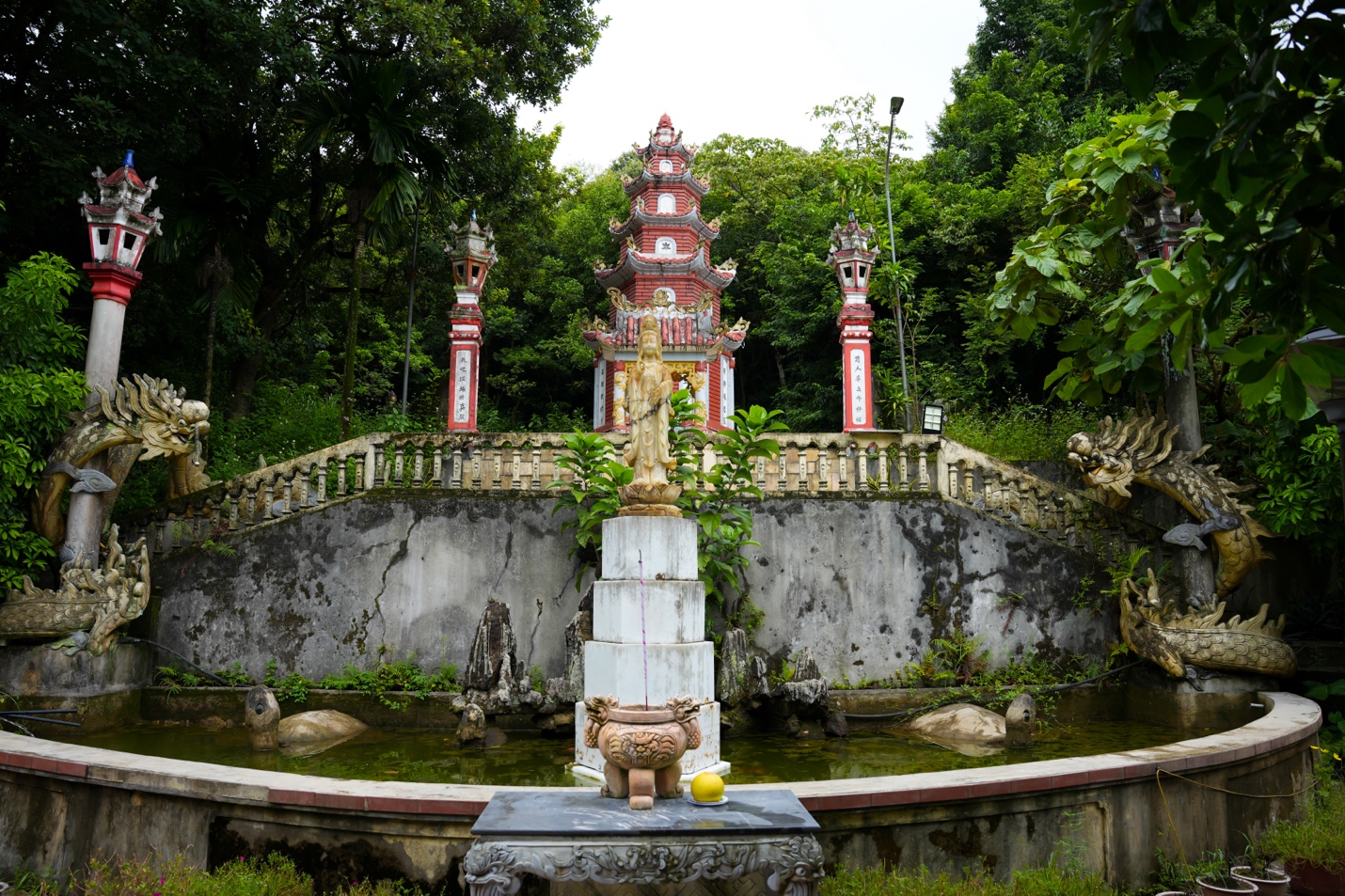 A statue in front of a pond Description automatically generated