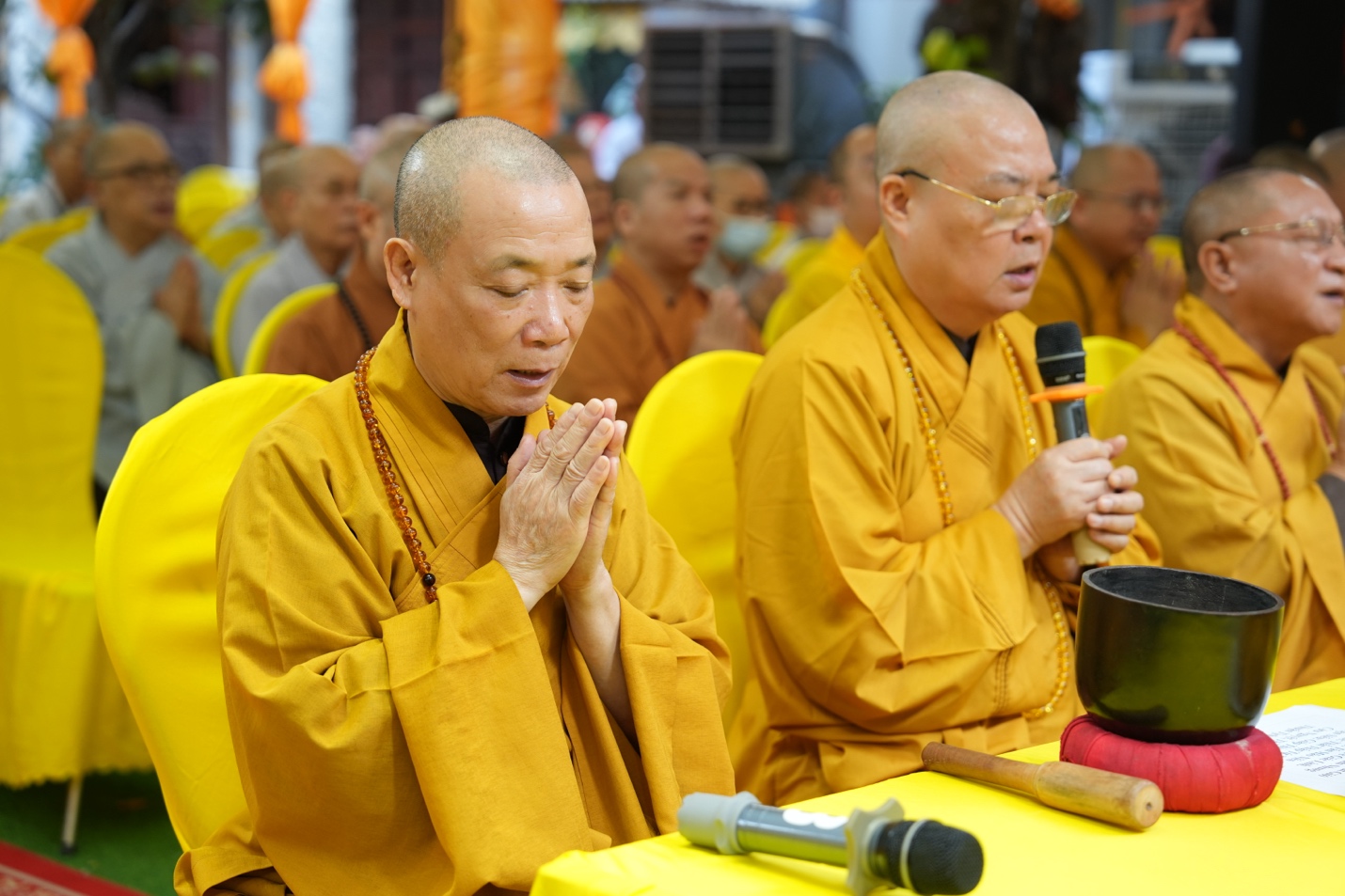 A group of men in yellow robes Description automatically generated