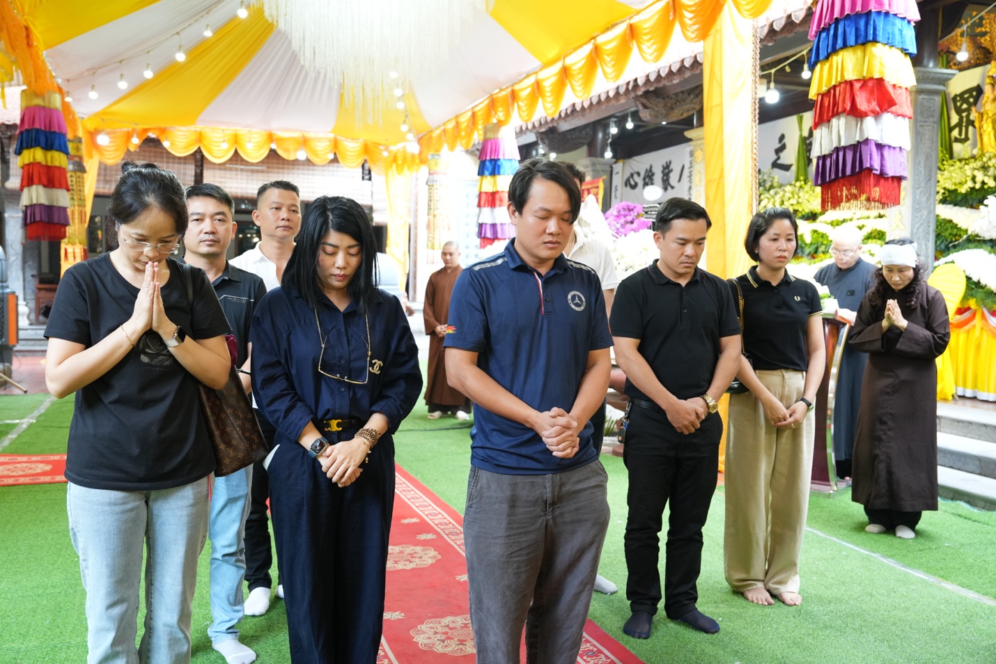 A group of people praying in a tent Description automatically generated