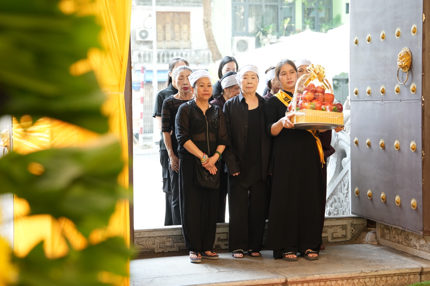 A group of people standing in front of a door Description automatically generated