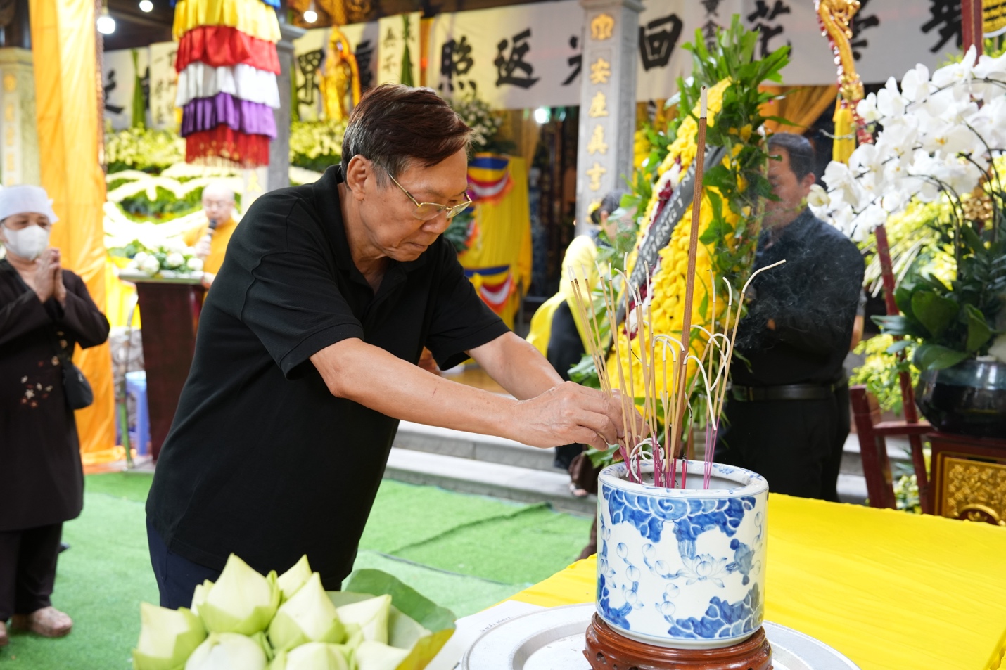 A person putting a plant on a table Description automatically generated