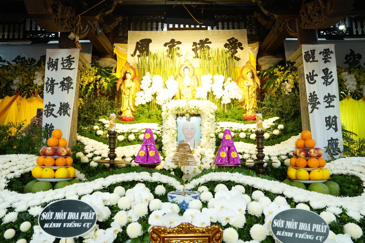 A shrine with flowers and fruits Description automatically generated