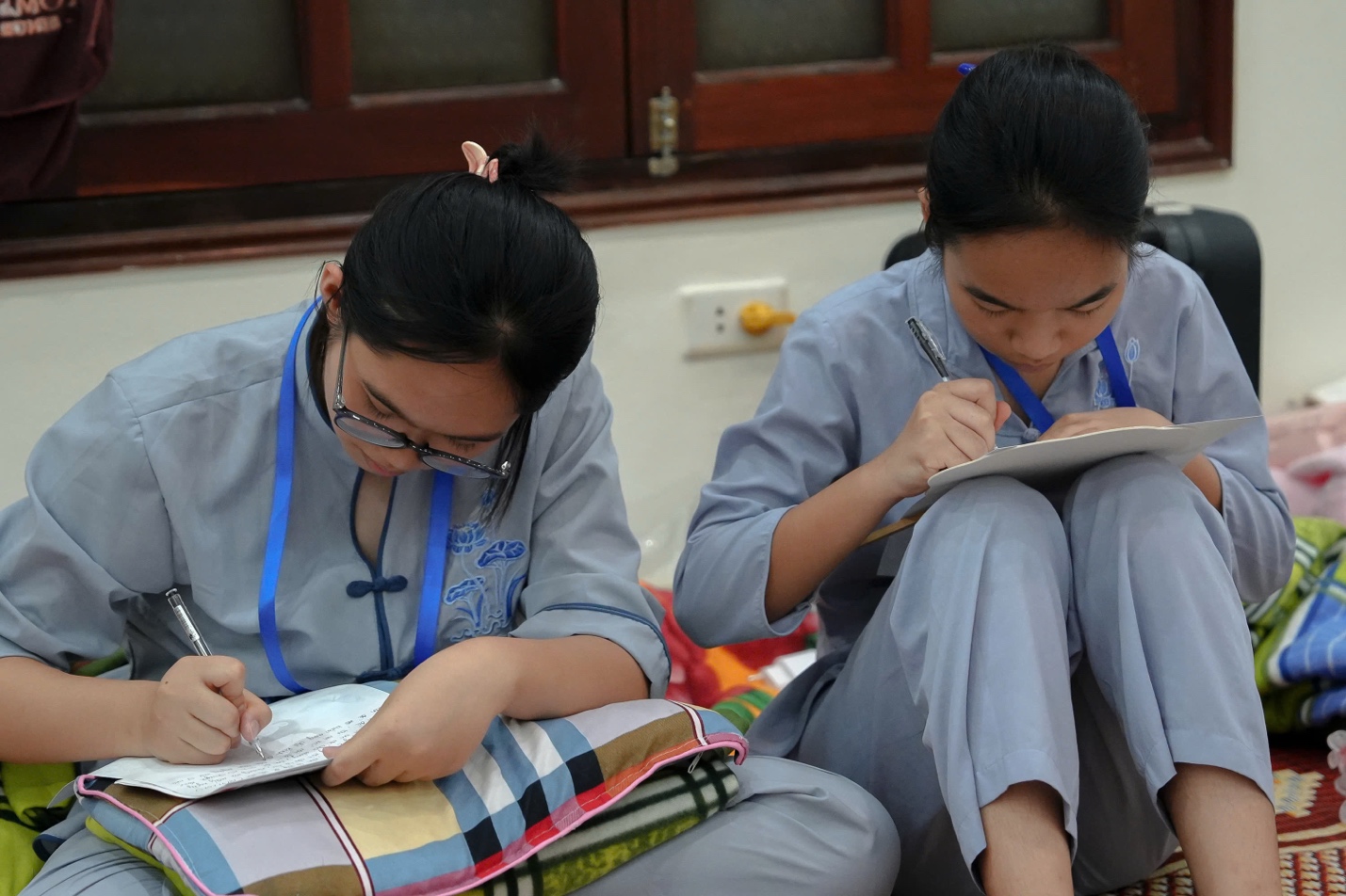 A couple of young women writing on a notebook

AI-generated content may be incorrect.