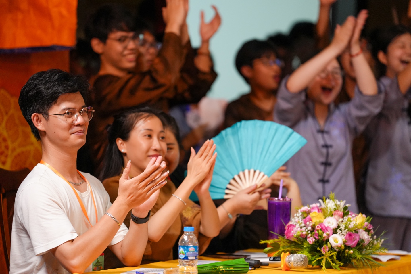 A group of people clapping at a table AI-generated content may be incorrect.