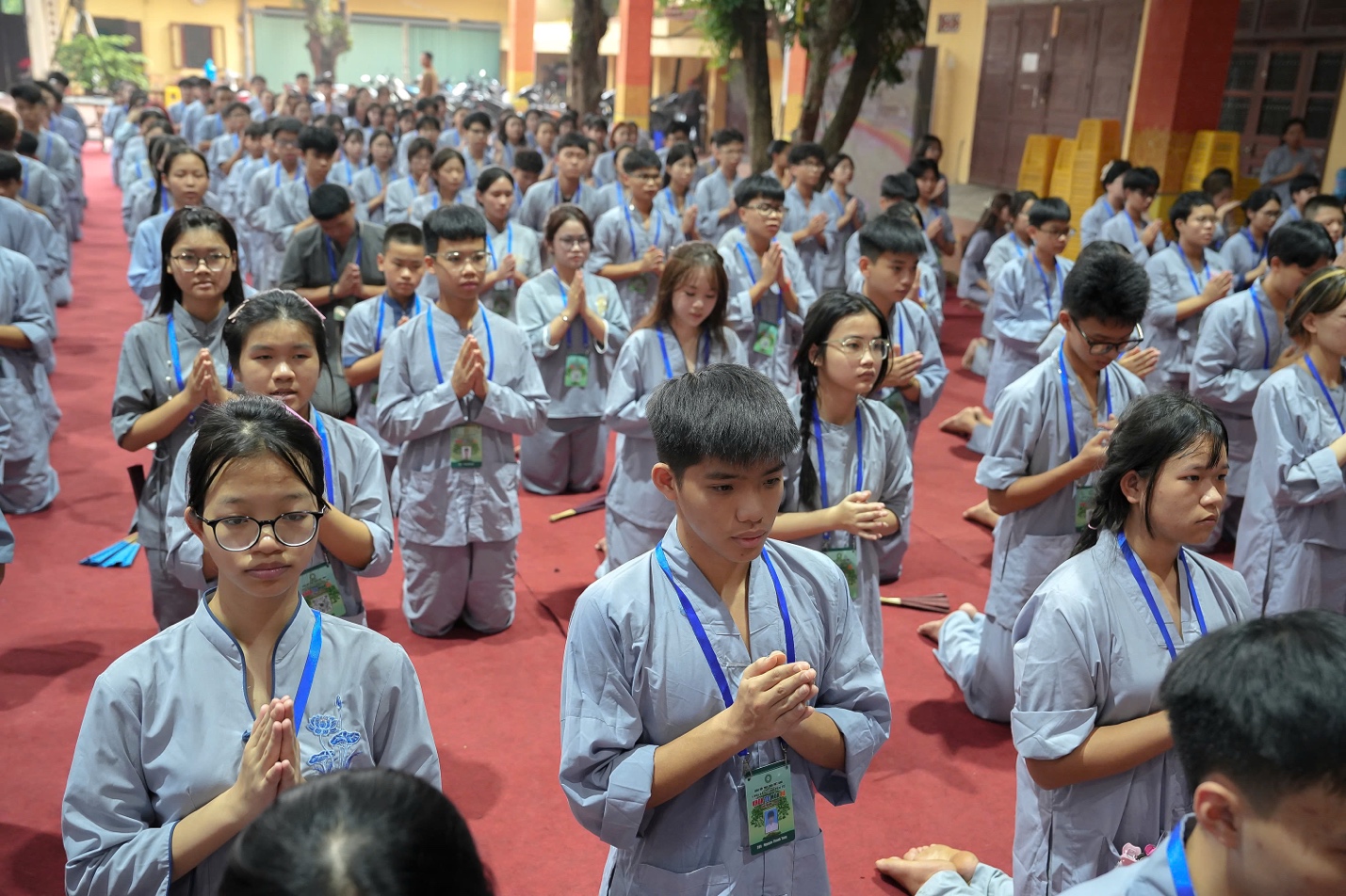 A group of people in grey robes praying AI-generated content may be incorrect.