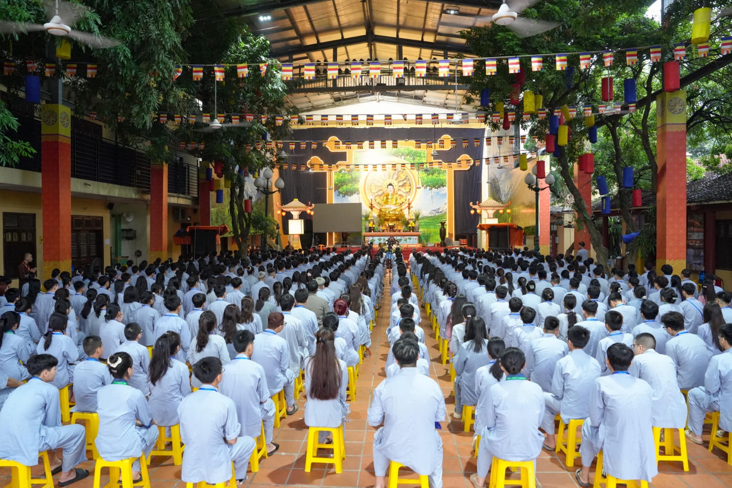 A group of people in white uniforms sitting on yellow stools AI-generated content may be incorrect.