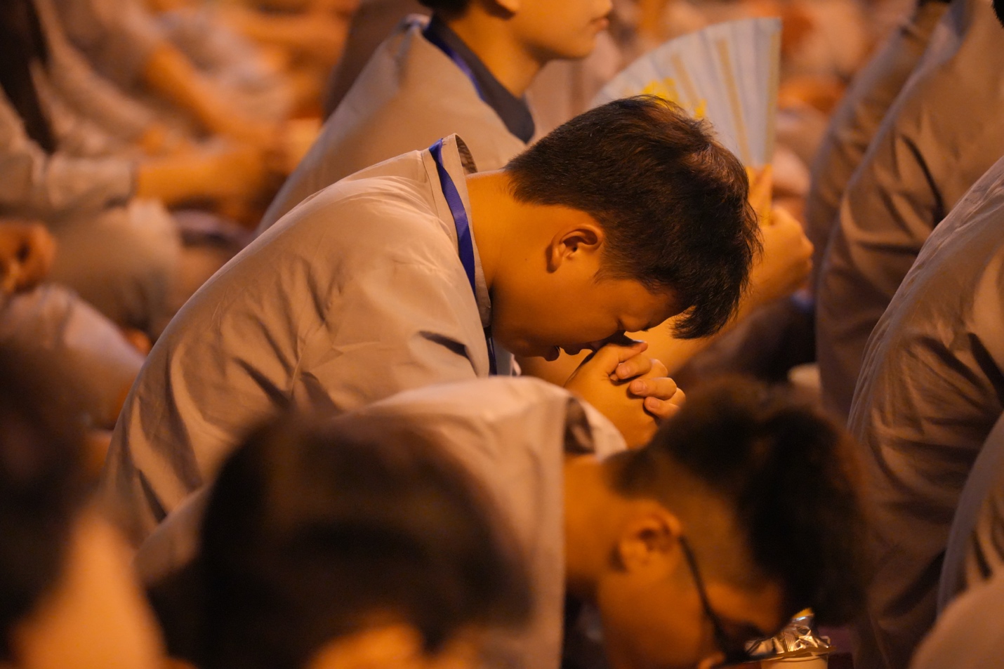 A group of people praying AI-generated content may be incorrect.