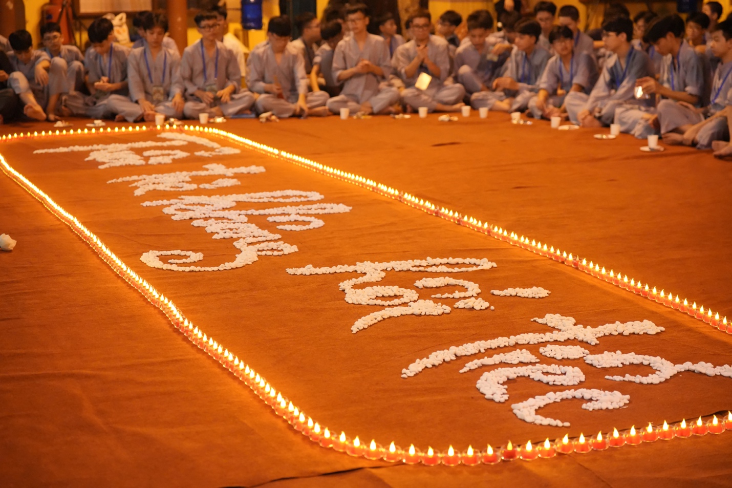 A group of people sitting in a circle with candles AI-generated content may be incorrect.