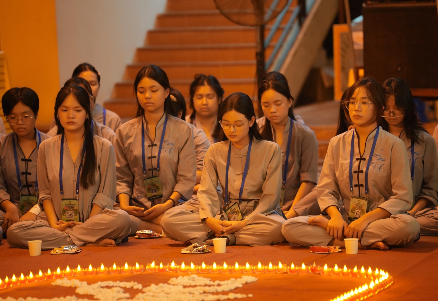 A group of women sitting on the floor with candles in the background AI-generated content may be incorrect.