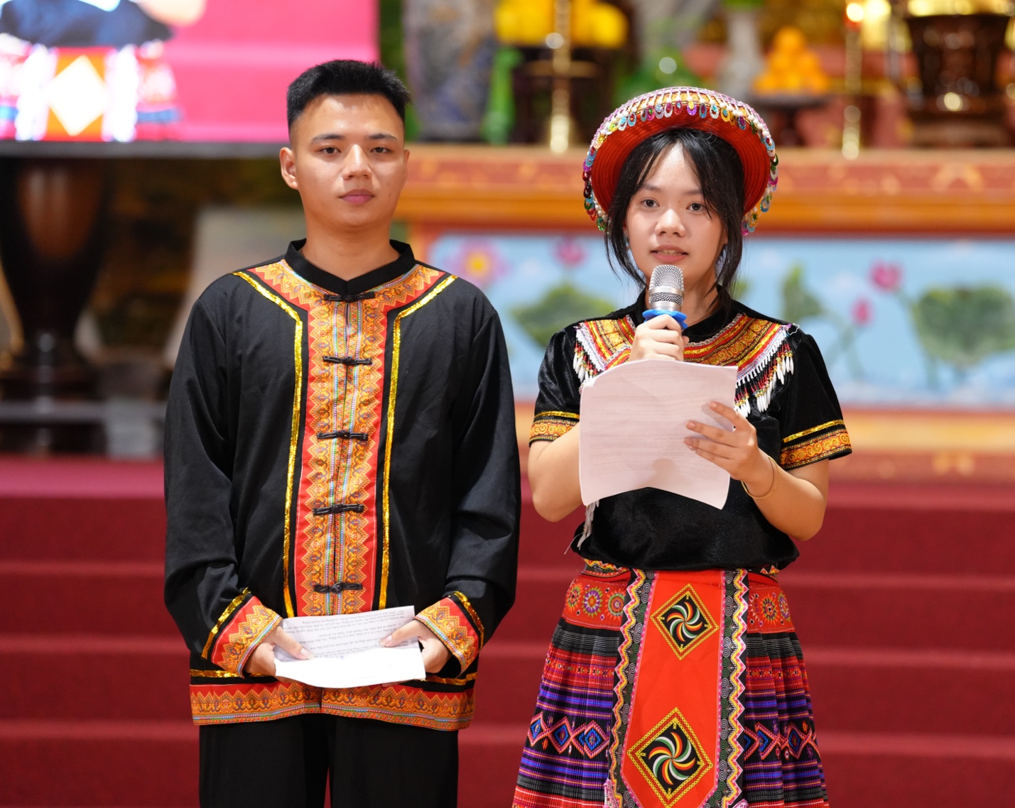 A person and person in traditional attire holding a microphone AI-generated content may be incorrect.
