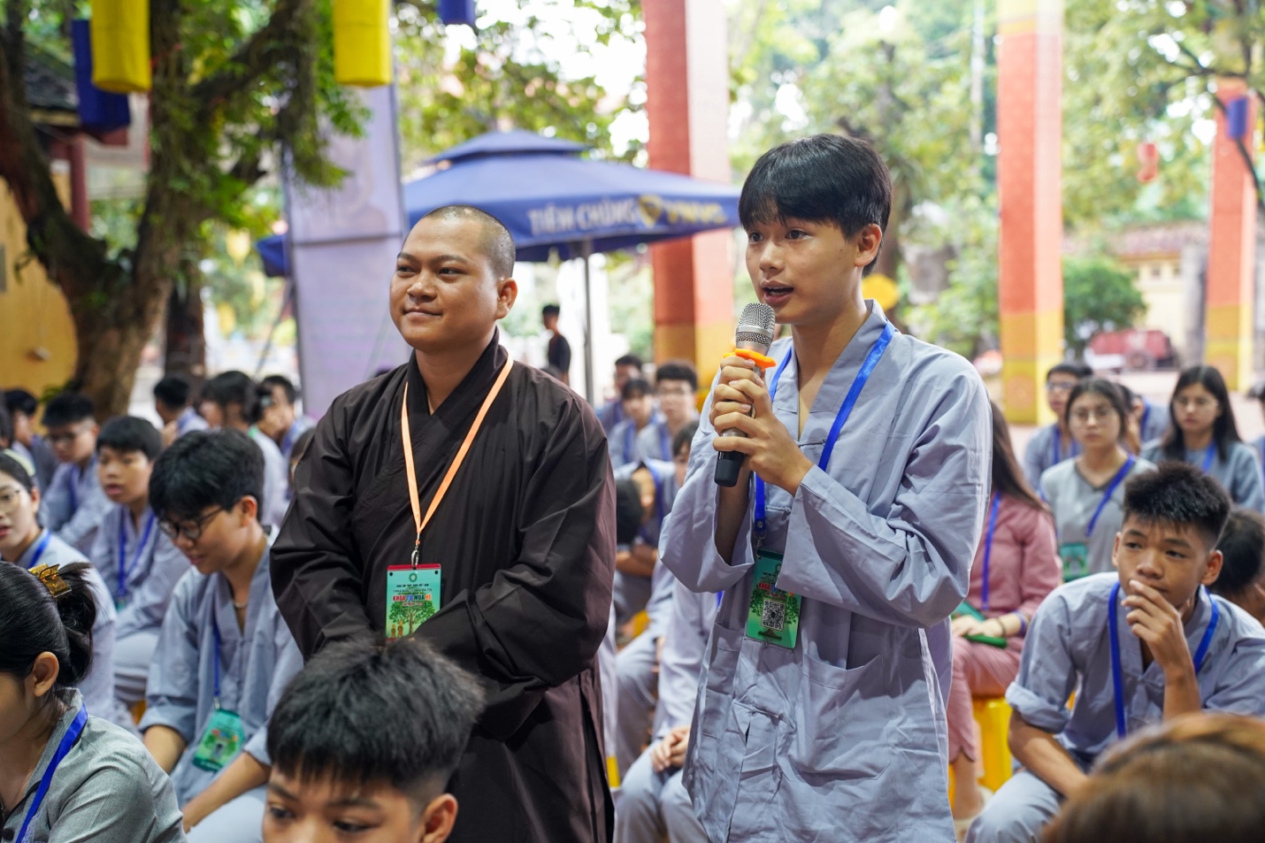 A person holding a microphone and standing next to a group of people AI-generated content may be incorrect.