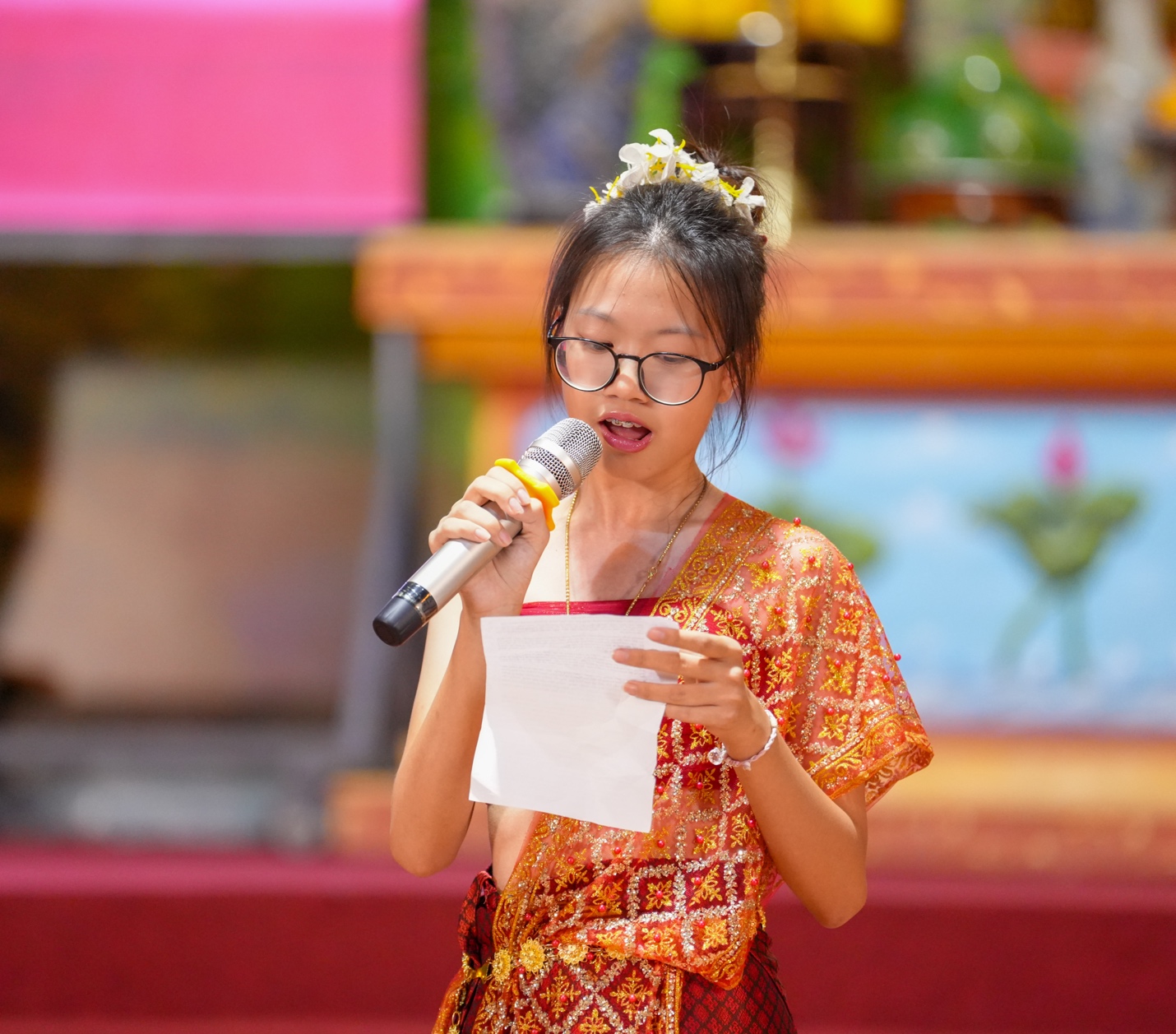 A person in a garment speaking into a microphone AI-generated content may be incorrect.