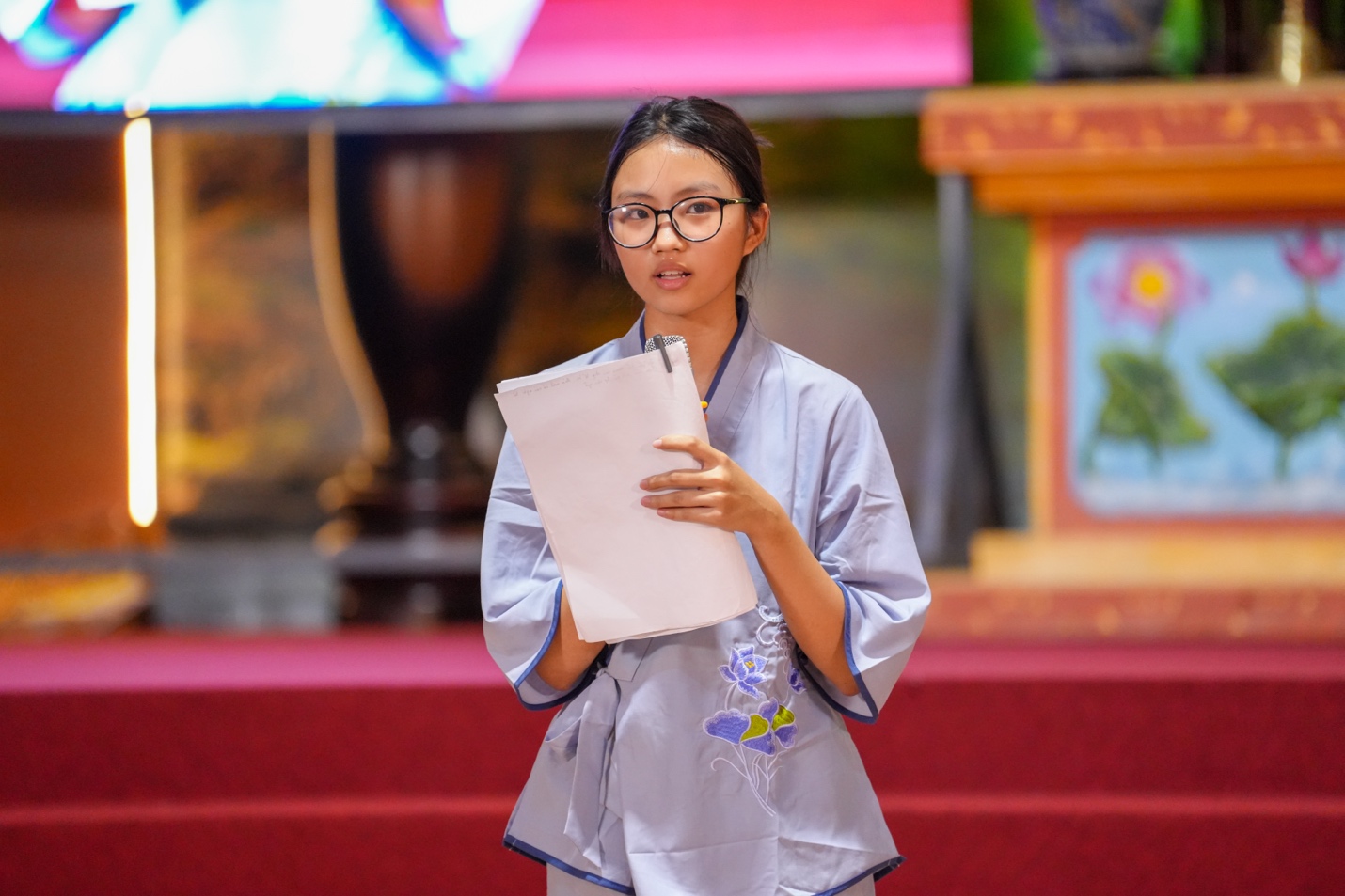 A person in a robe holding a paper AI-generated content may be incorrect.