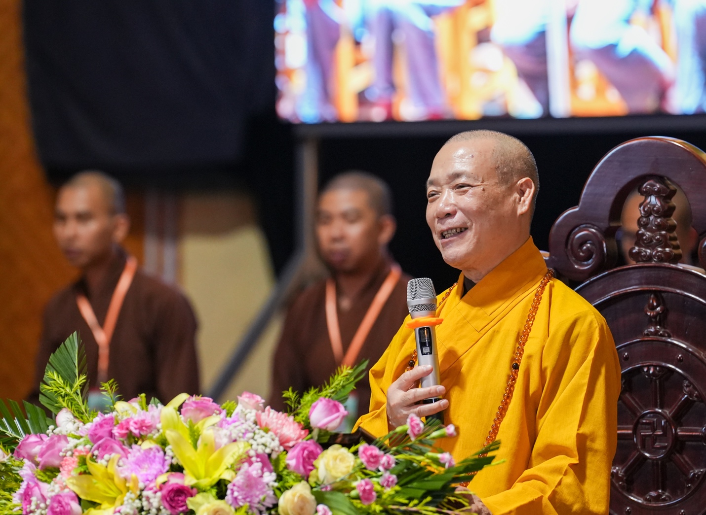 A person in a yellow robe holding a microphone AI-generated content may be incorrect.