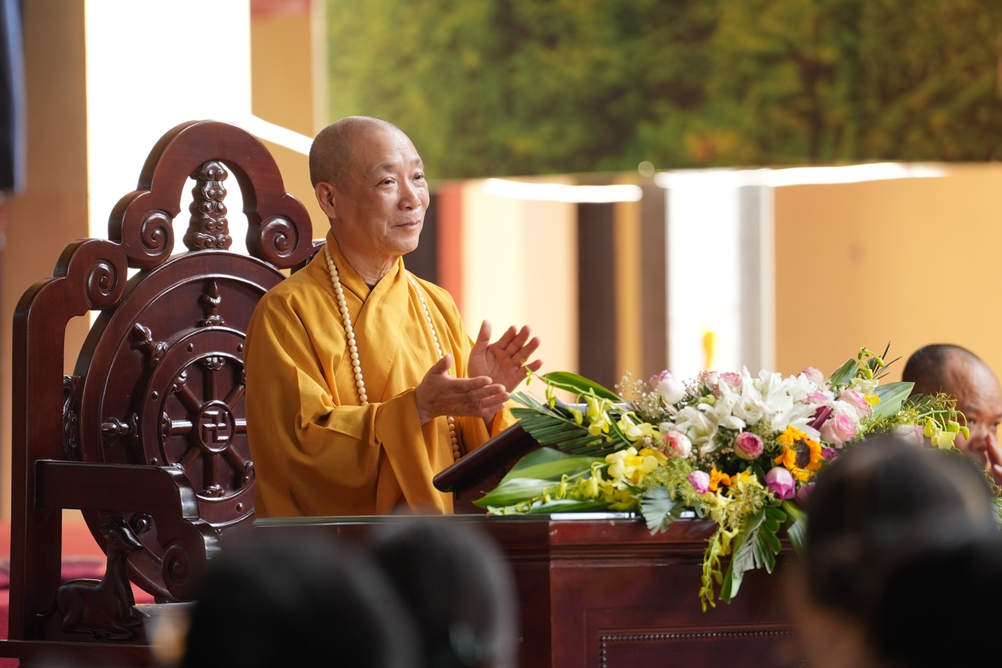 A person in a yellow robe standing at a podium AI-generated content may be incorrect.