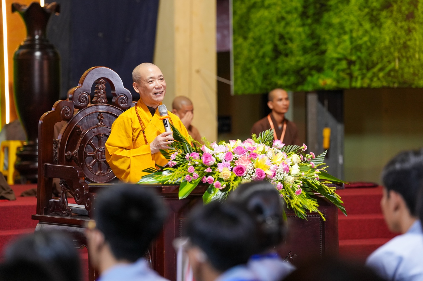 A person in a yellow shirt speaking into a microphone AI-generated content may be incorrect.