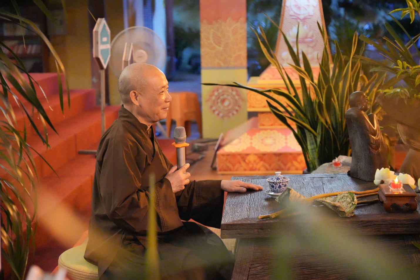 A person sitting at a table holding a microphone AI-generated content may be incorrect.