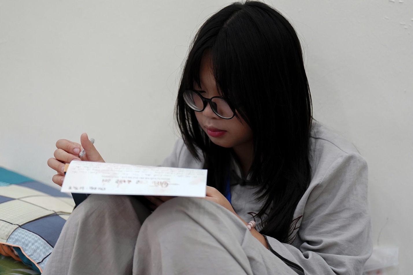 A person sitting on the floor reading a letter

AI-generated content may be incorrect.