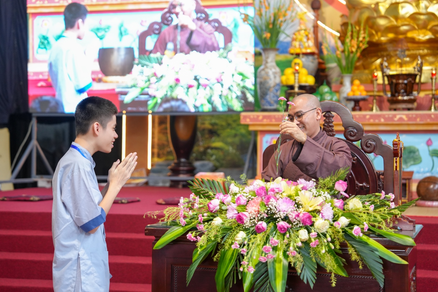 A person standing next to a person standing next to a person standing in front of a flower arrangement AI-generated content may be incorrect.