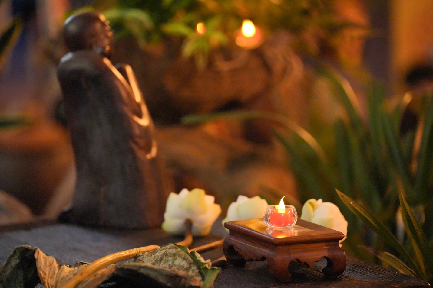 A small statue with a candle on a table AI-generated content may be incorrect.