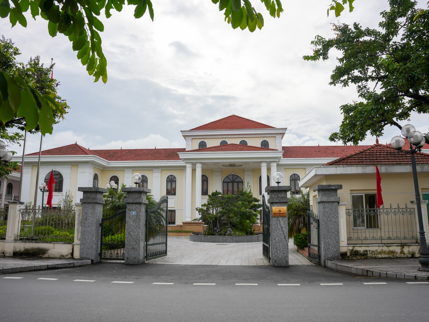 A white building with red roof and a gated entrance AI-generated content may be incorrect.