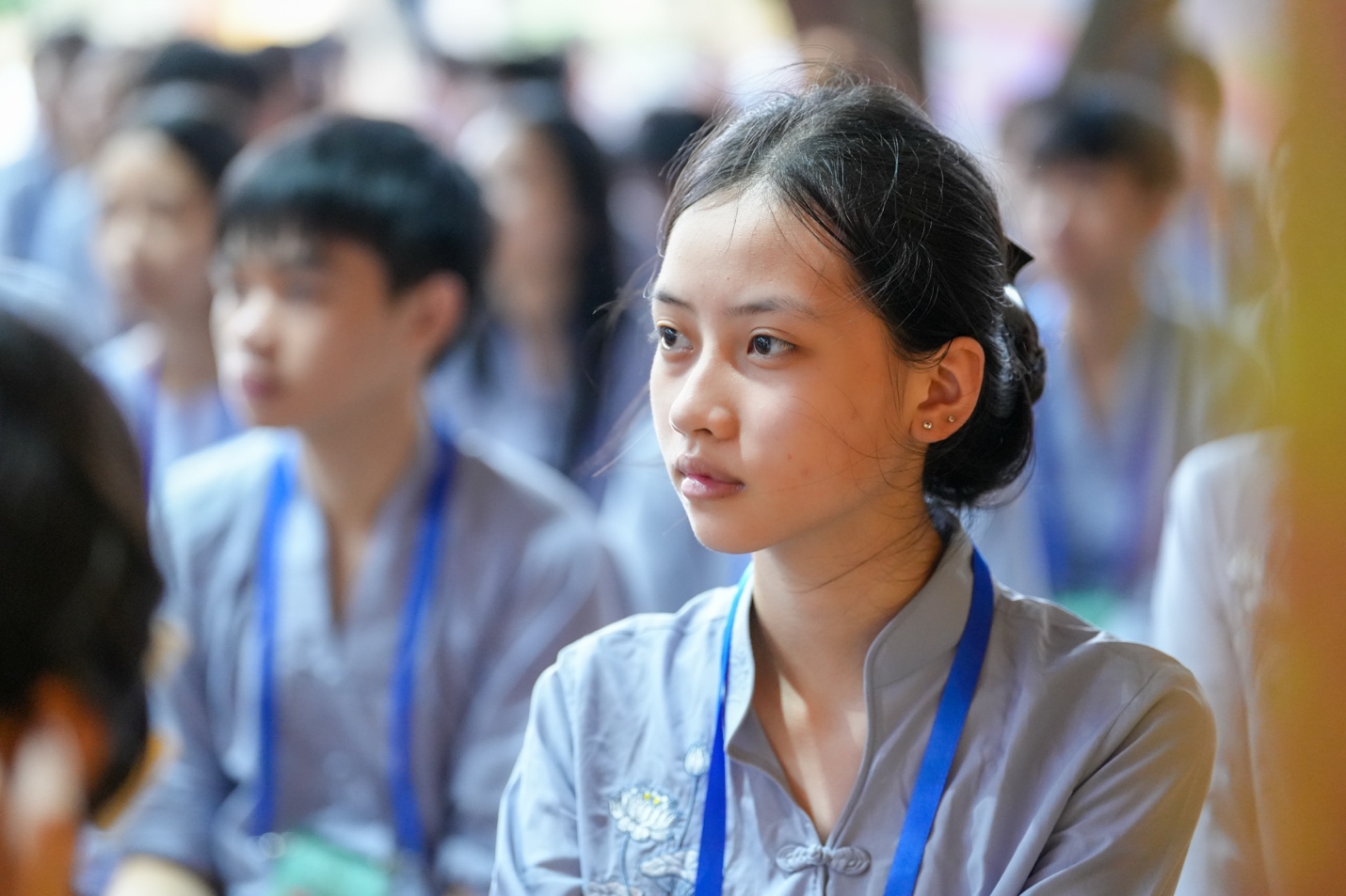 A young person wearing a blue lanyard AI-generated content may be incorrect.