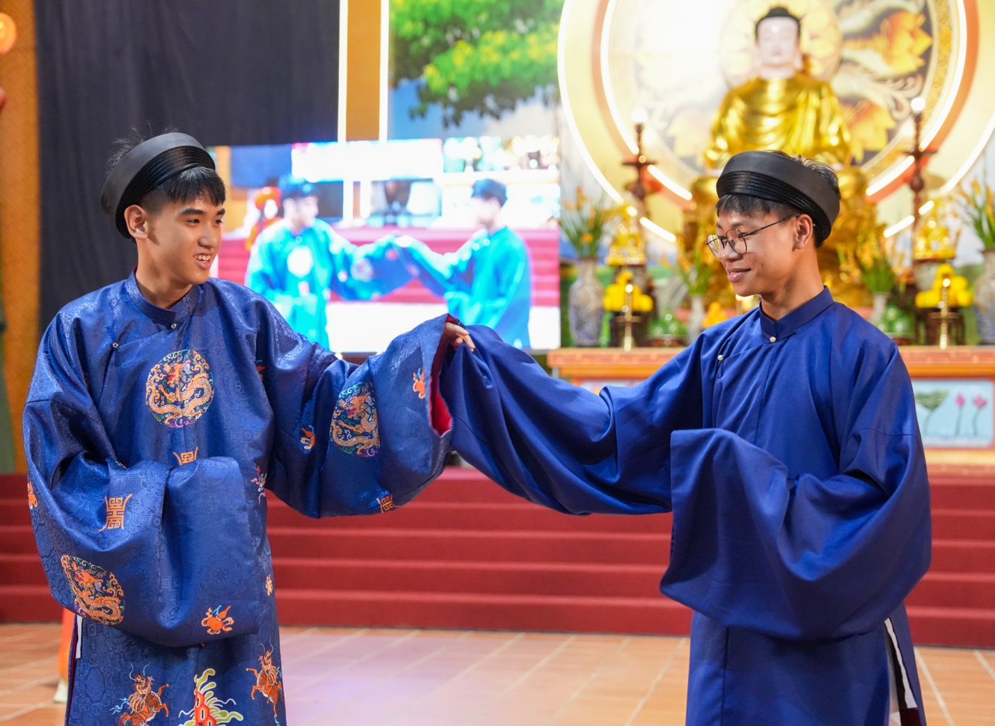 Two men wearing blue robes and hats AI-generated content may be incorrect.
